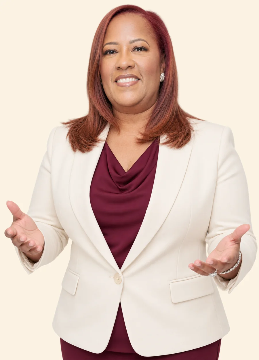 Aisha Smith smiling in a cream blazer and burgundy top